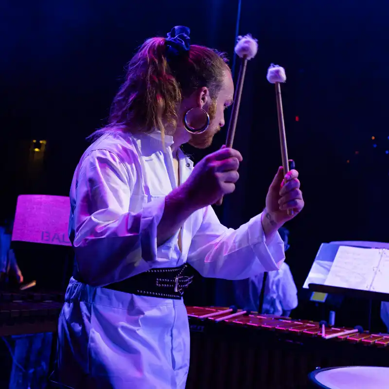 A percussionist poised to strike with mallets with the New Wave Orchestra at Balboa Theatre in San Diego