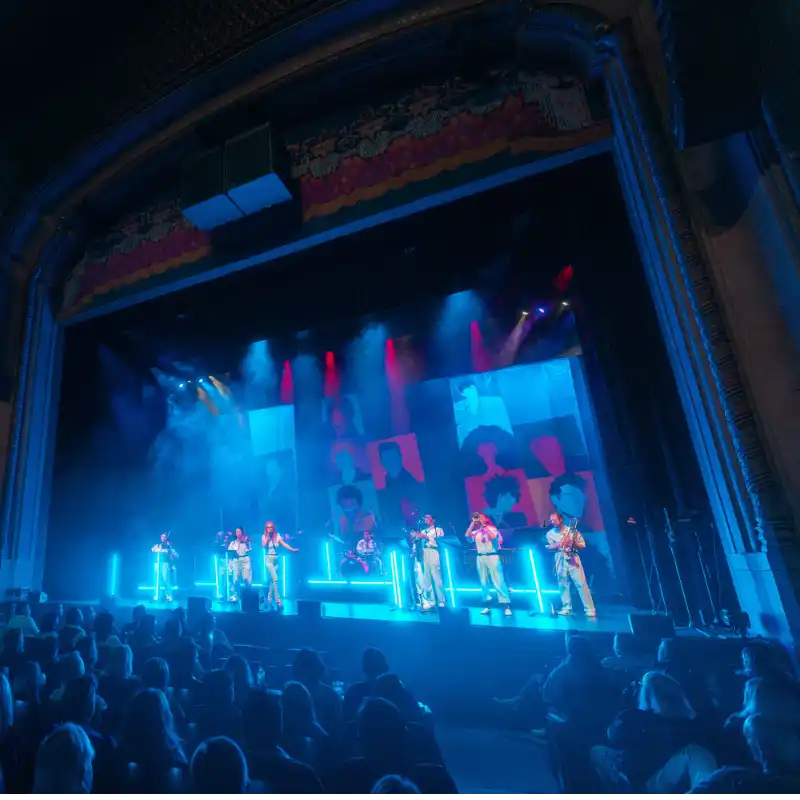 The New Wave Orchestra on a neon lit stage with a retro pop art style backdrop at Balboa Theatre in San Diego
