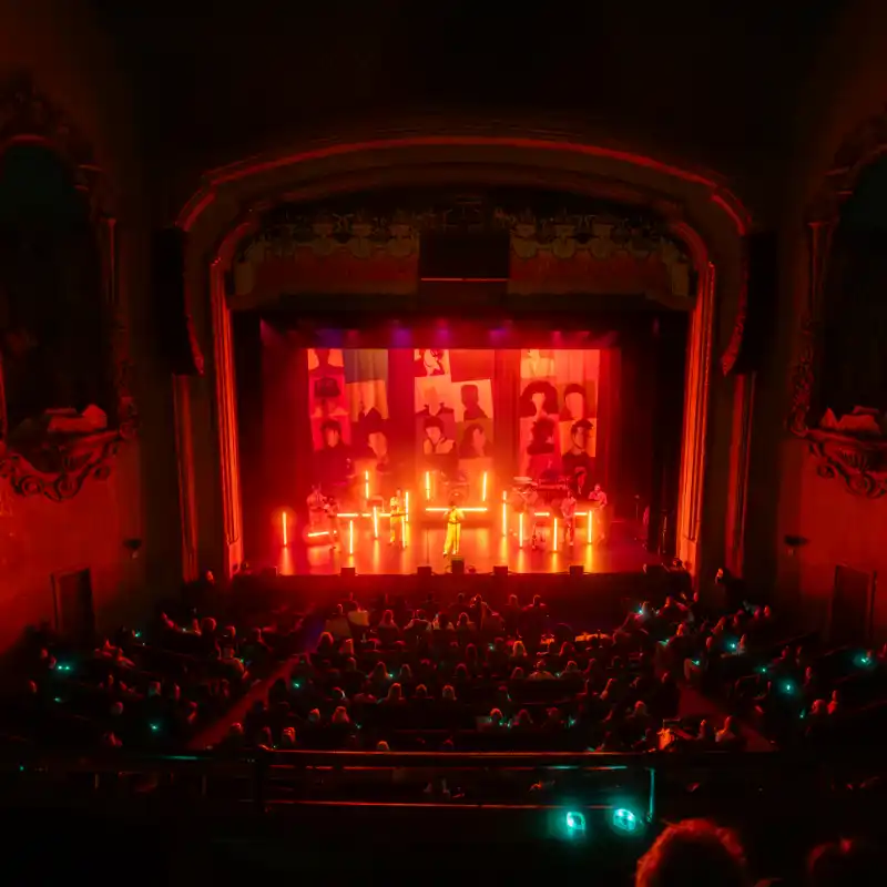 The Neon lit stage casts a retro-futuristic glow over the crowd as the New Wave Orchestra play at Balboa Theatre in San Diego