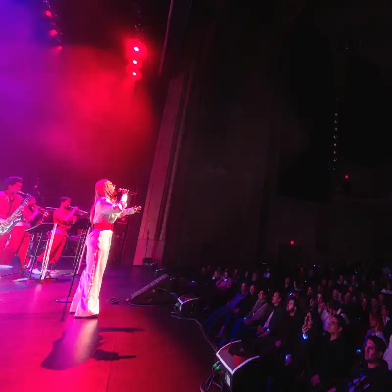 A singer looks on to a captivated crowd with the New Wave Orchestra at Balboa Theatre in San Diego